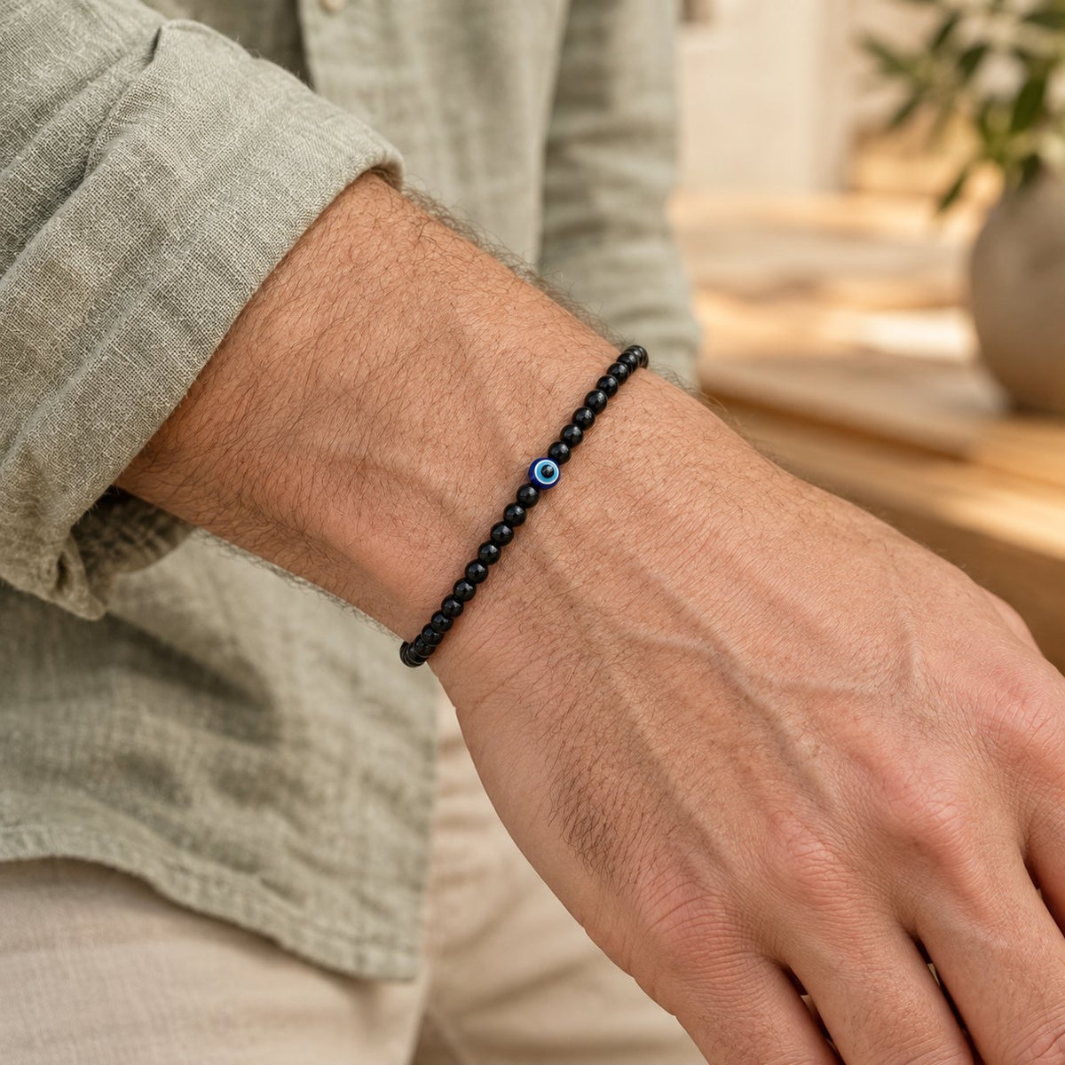 Black Onyx Bracelet with Evil Eye Symbol, worn on the wrist by a man