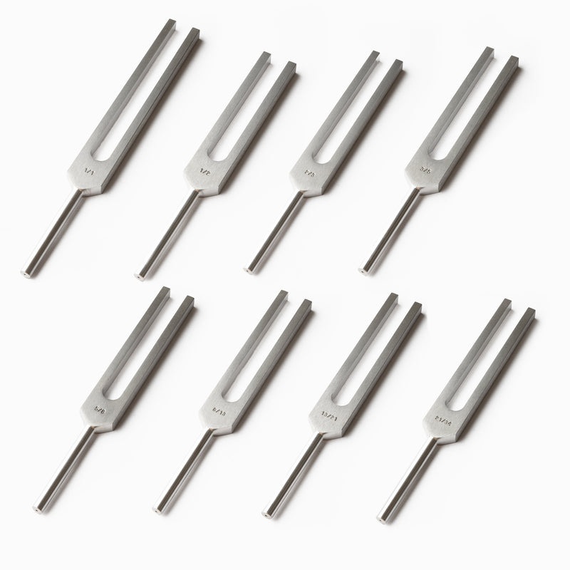 Eight metal tuning forks in two rows from the Fibonacci Healing Tuning Fork Set