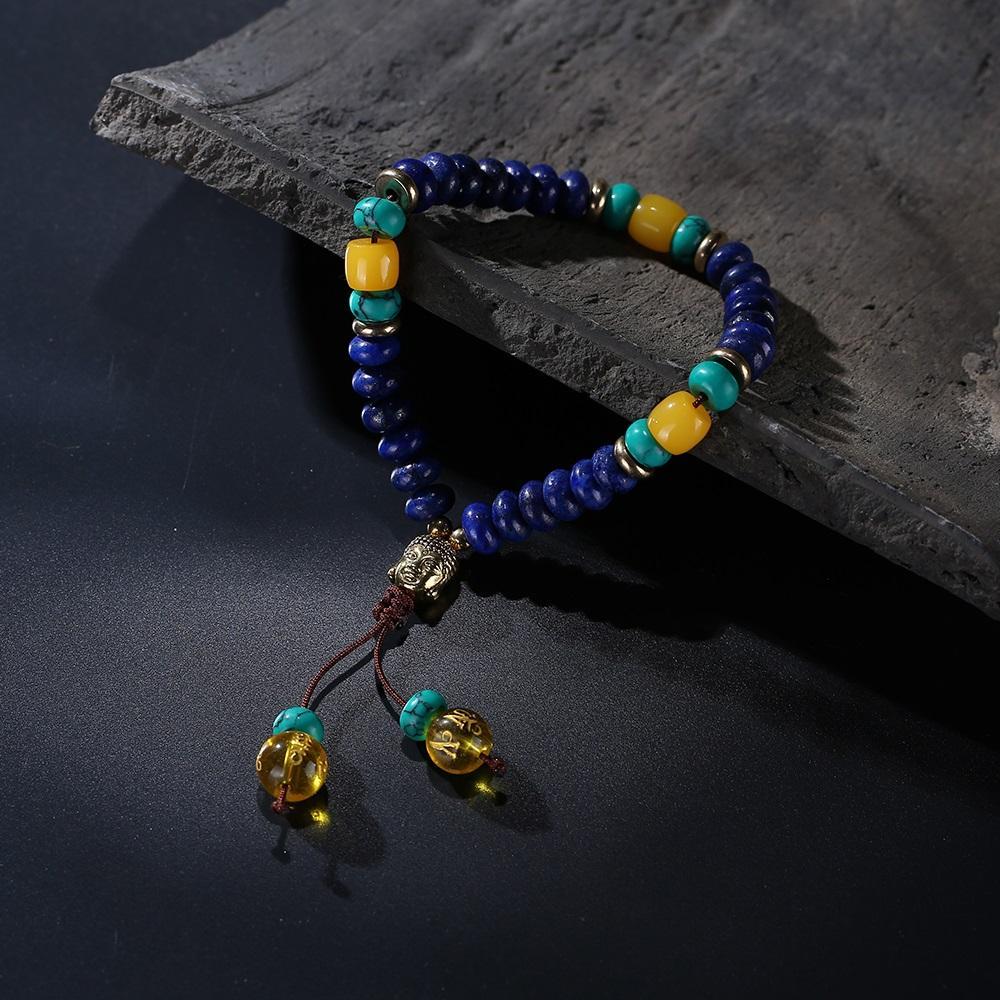 Flacher natürlicher Lapislazuli-Stein mit 6-Silben-Mantra-Quaste und Mala-Armband mit Buddhakopf-Charm
