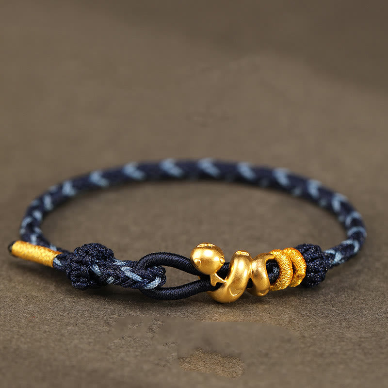 Goldfarbenes Schlangenarmband mit roter Schnur für Stärke und Schutz