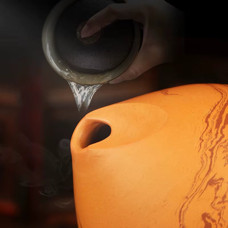 Orange silicone cutting board with handle alongside Handmade Ceramic Xun Flute