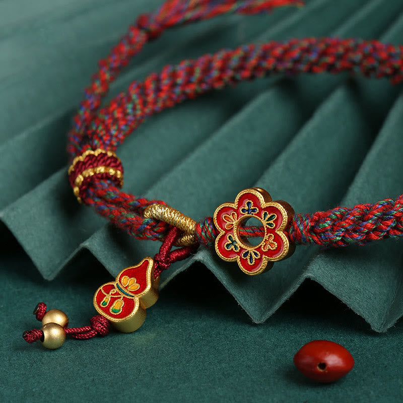 Handgemachtes buntes Kürbisblumen-Schutzarmband mit roter Schnur
