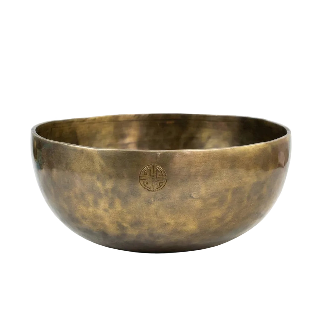 Hammered brass singing bowl with etched symbol design for healing and meditation