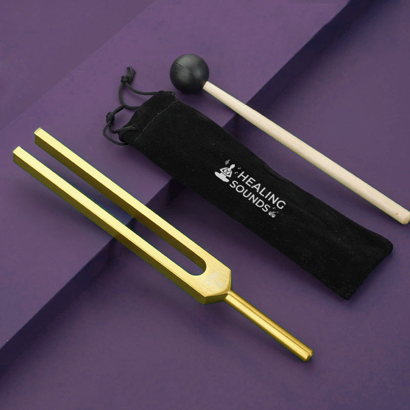 Gold-colored Otto C 128 Hz Tuning Fork with black storage pouch for sound healing therapy