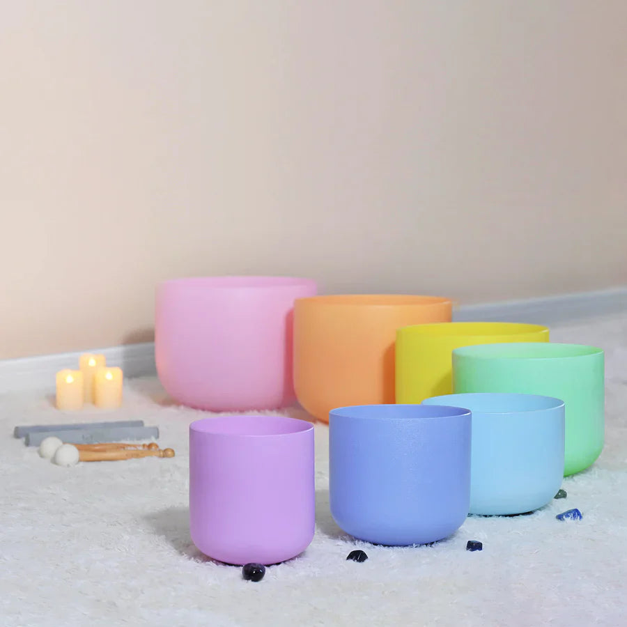 Rainbow-colored crystal singing bowls arranged in a curve for meditation and healing