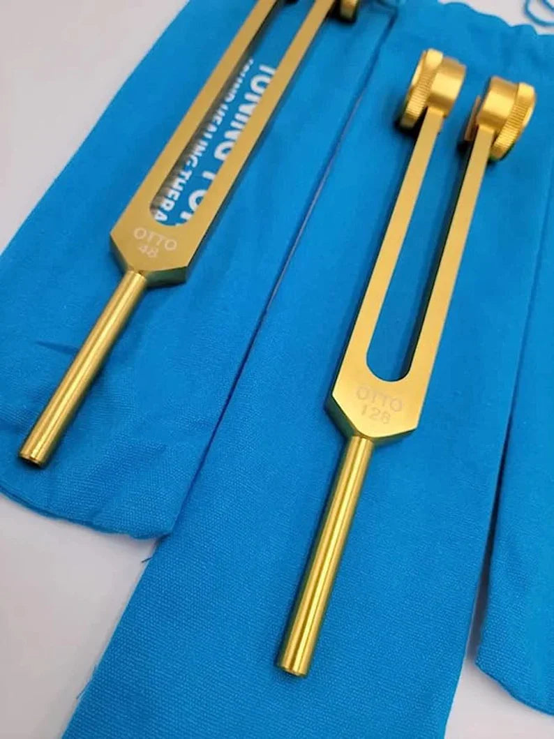 Gold-colored Otto Tuners Weighted Tuning Forks Set on blue fabric background