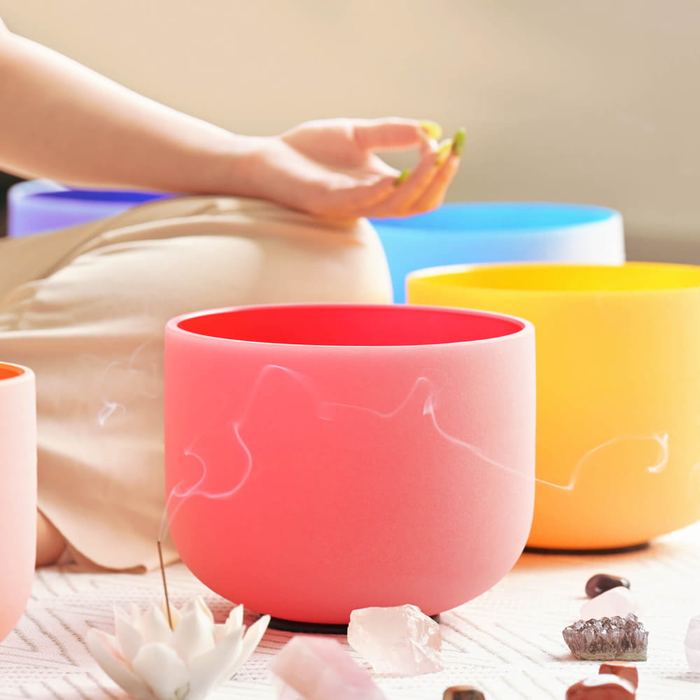 Colorful crystal singing bowls and crystals near Red Color C Note Root Chakra Bowl