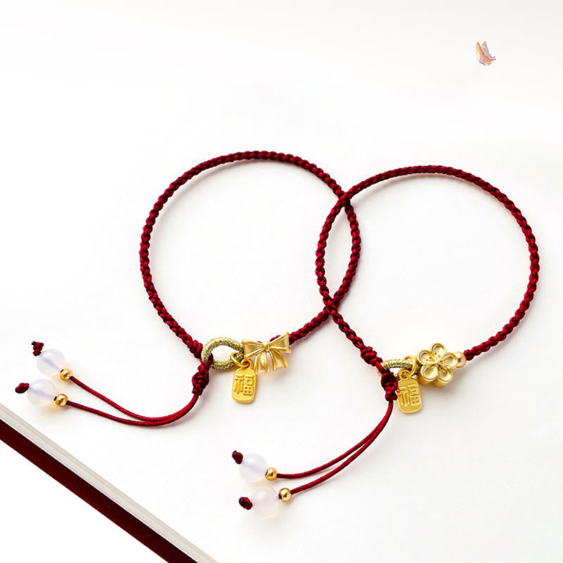 Rotes Schnurarmband mit Fu-Charm-Anhänger und Pfirsichblüten-Detail
