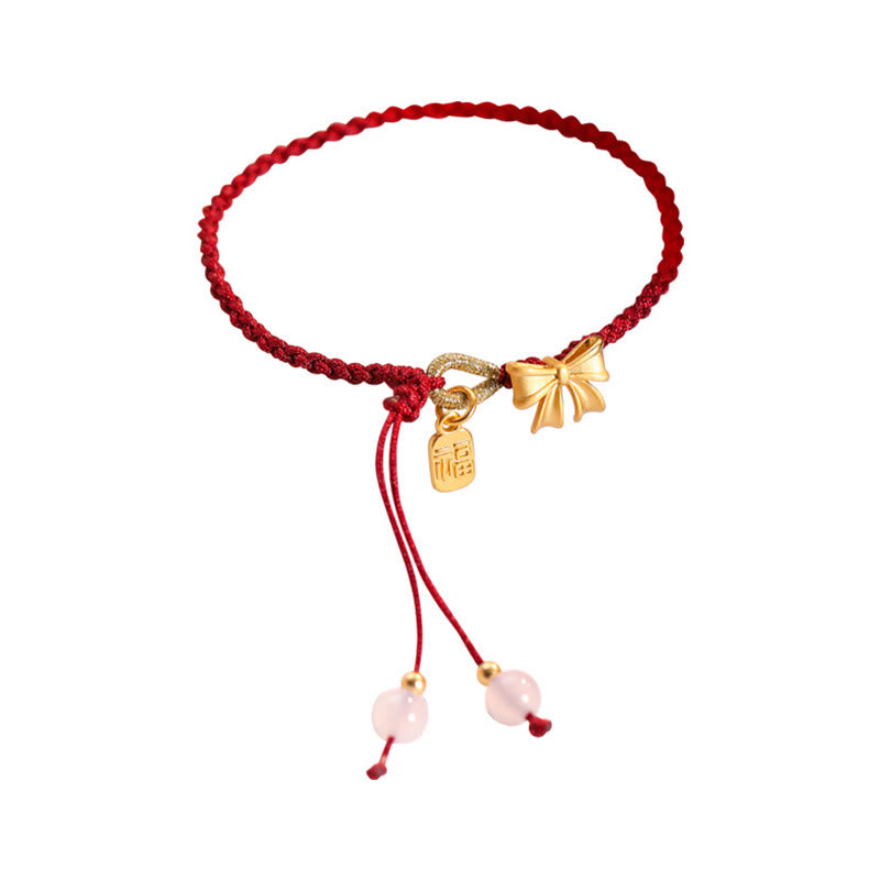 Rotes Schnurarmband mit Fu-Charm-Anhänger und Pfirsichblüten-Detail