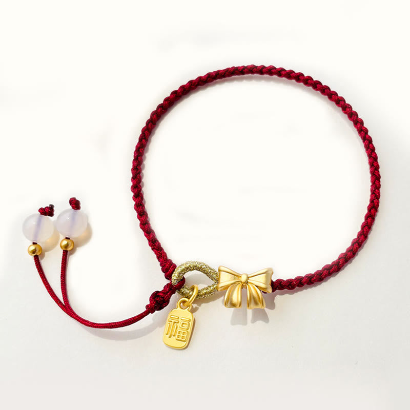Rotes Schnurarmband mit Fu-Charm-Anhänger und Pfirsichblüten-Detail