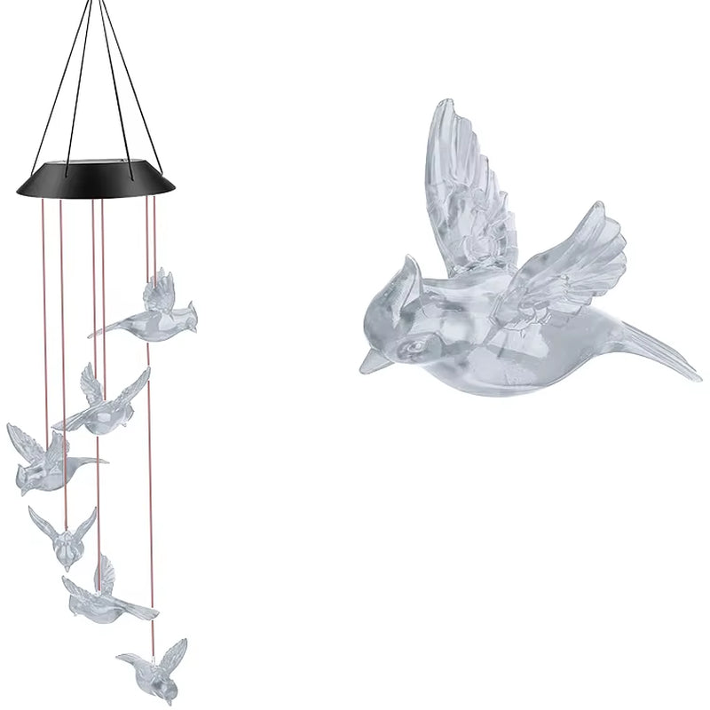 Translucent dove ornaments on a black top of Solar-Powered Snowflake Wind Chime Lights