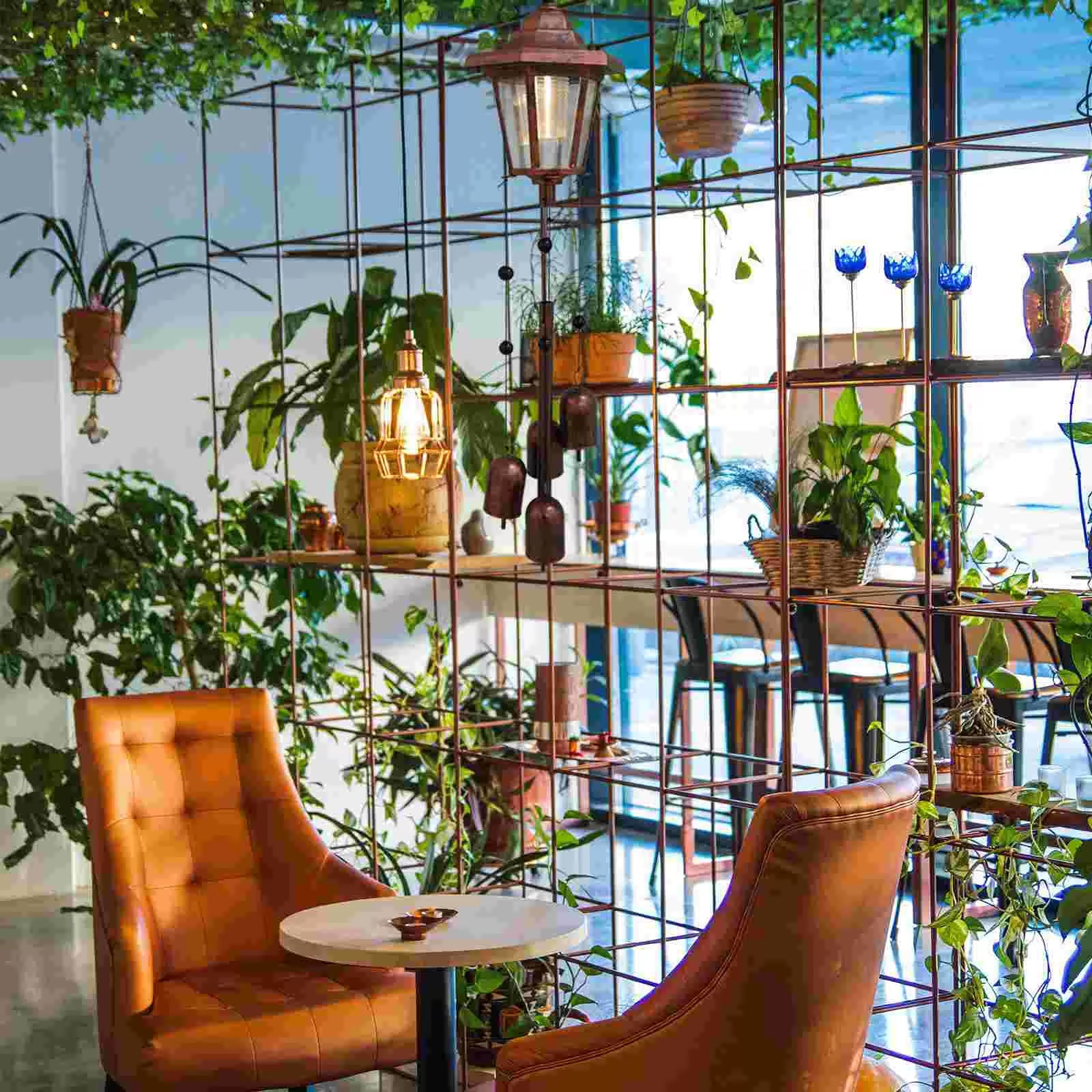 Two tufted cognac leather chairs by a round bistro table with Solar Wind Chimes